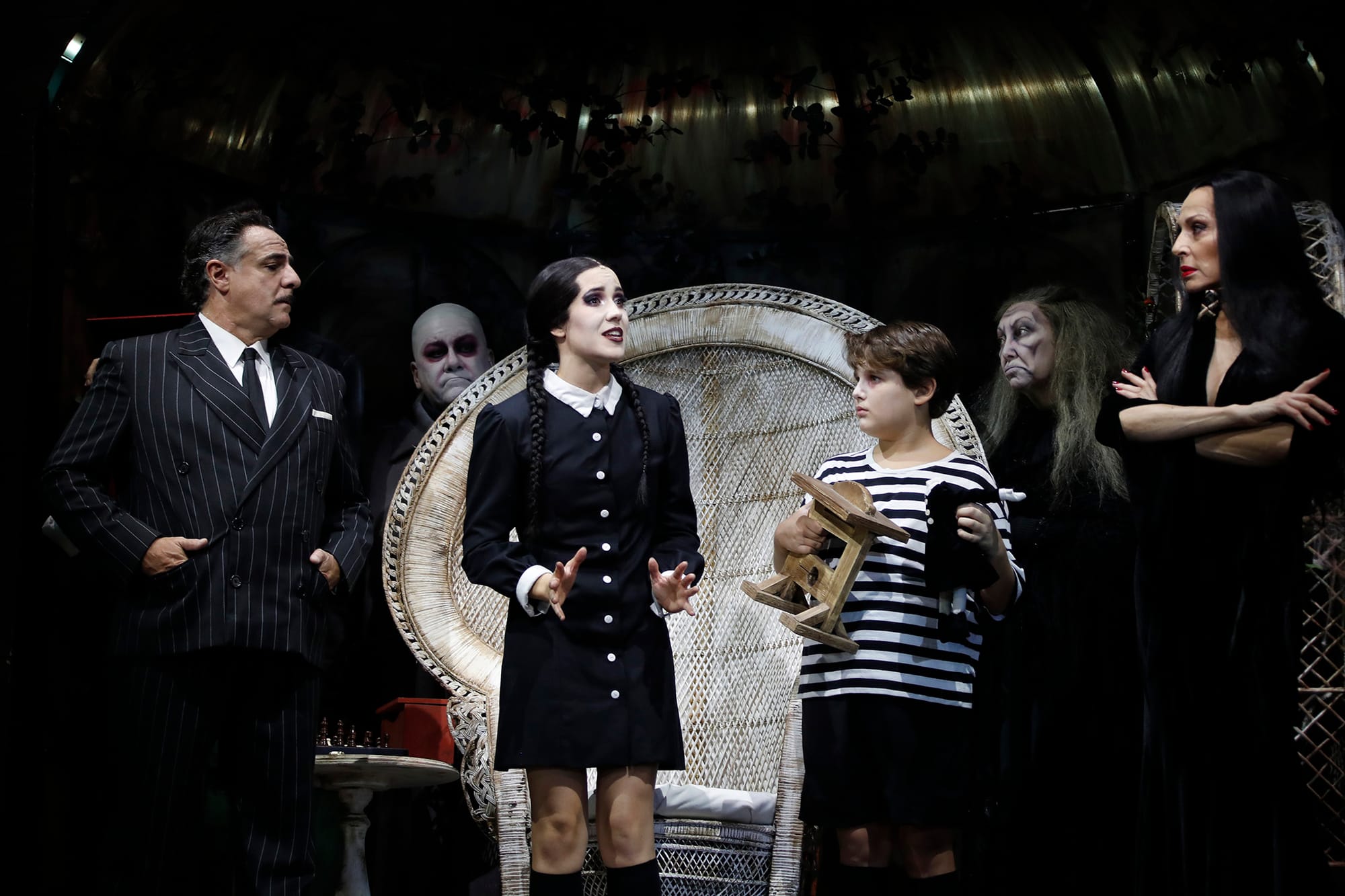 Elenco completo del musical La Familia Addams posando en formación sobre el escenario del Teatro Calderón, con iluminación lúgubre y vestuario gótico característico.