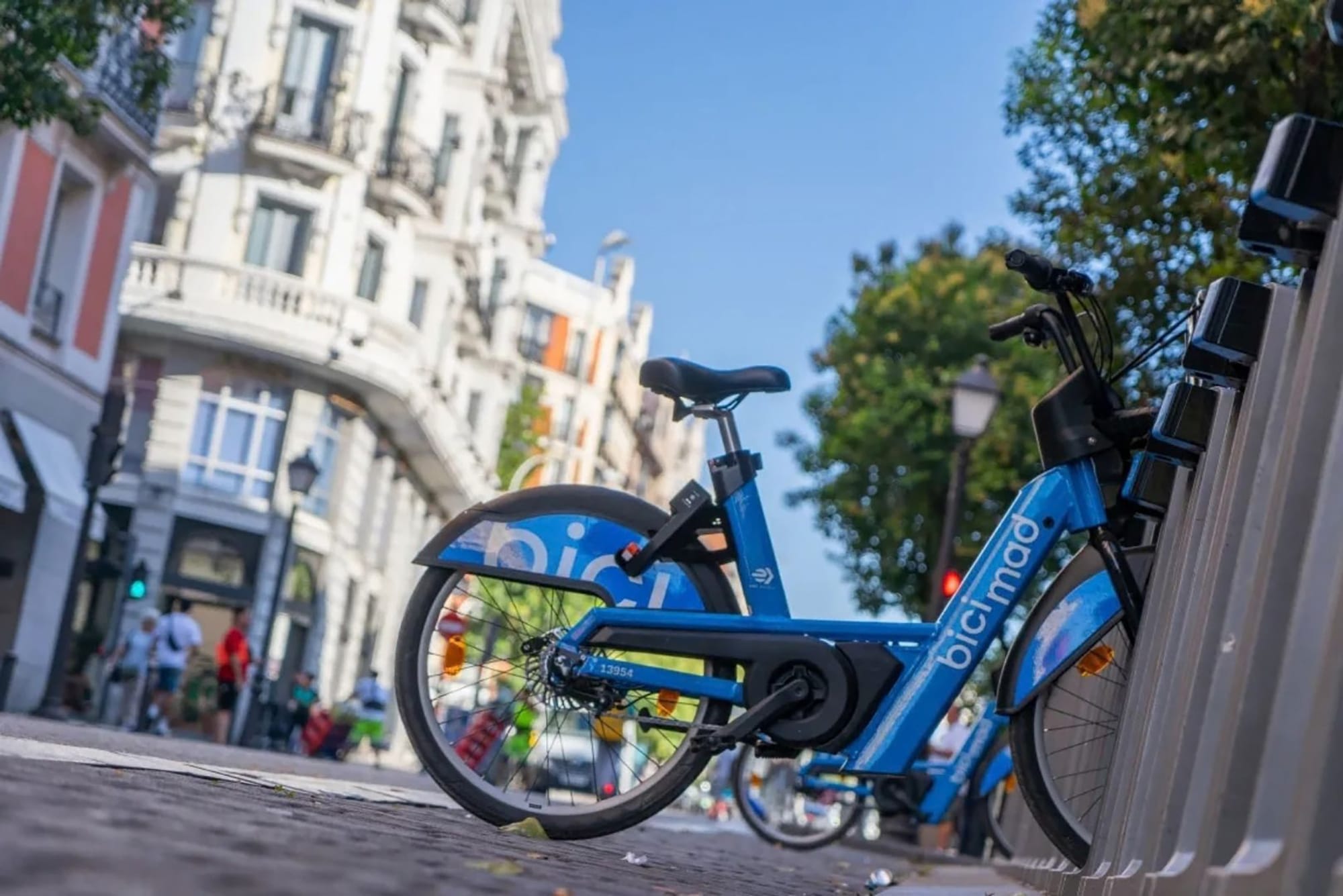 Detalle de la batería integrada en el cuadro de una bicicleta eléctrica de BiciMAD mientras se recarga en su base.