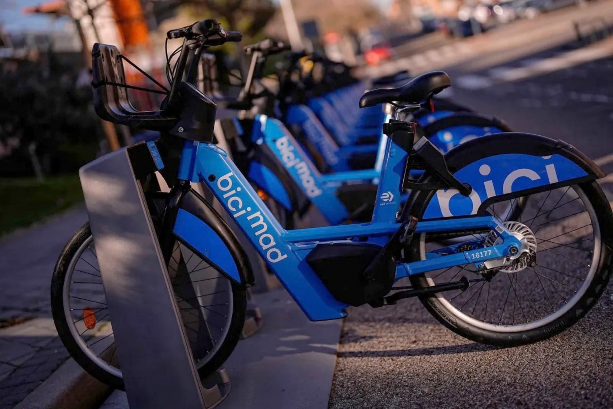Vista panorámica de una larga fila de bicicletas eléctricas azules de BiciMAD ancladas en su estación.