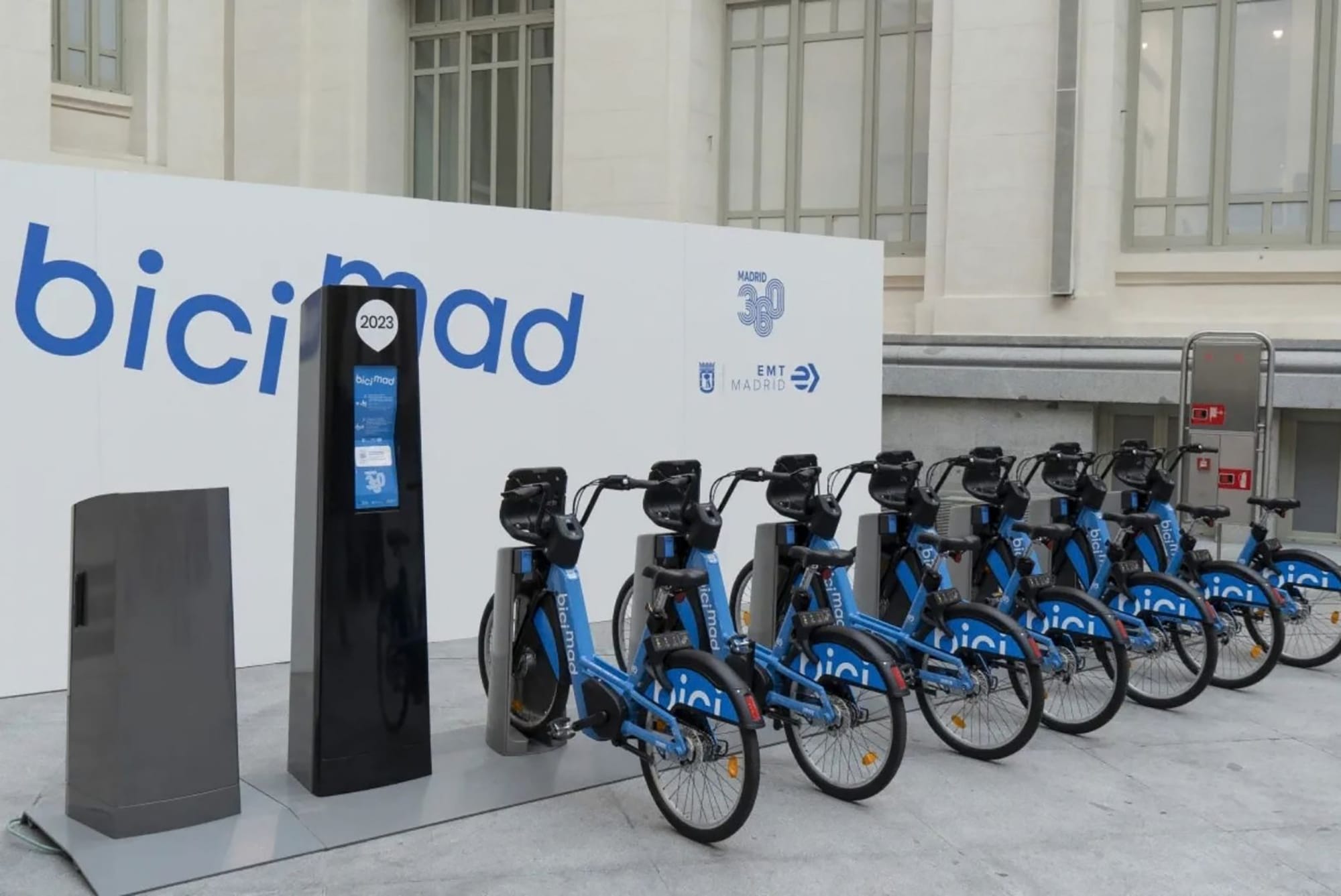 Sello circular verde de energía renovable 100% pegado en el poste de anclaje de una estación de BiciMAD.
